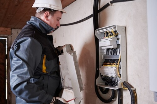 A SafeContractor-accredited technician fits cables while wearing protective clothing